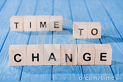 close up view of arranged wooden blocks into time to change phrase on blue Stock Photo