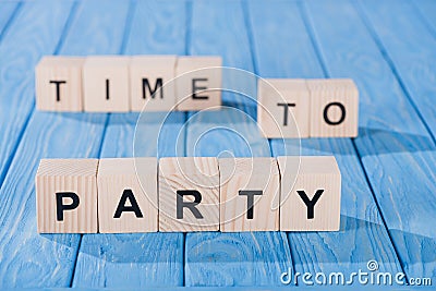 close up view of arranged wooden blocks into time to party phrase on blue Stock Photo