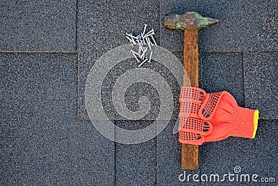 Close up view on bitumen shingles on a roof with hammer,nails and stationery knife background Stock Photo