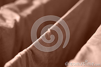 Close up view of brown fabric folds creating geometric patterns in soft light Stock Photo