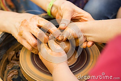 A close up view on ceramic production process on potter`s wheel with children. Clay crafts with kids concept Stock Photo