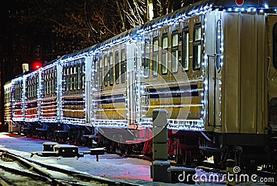 Close-up view of Christmas decorated train by lights. Train arrived at the station Editorial Stock Photo