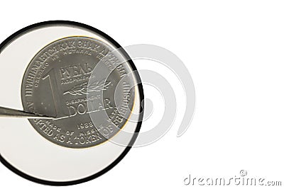 Close up view of coin under magnifying glass made of missle metal and symbolizing token of friendship. Stock Photo