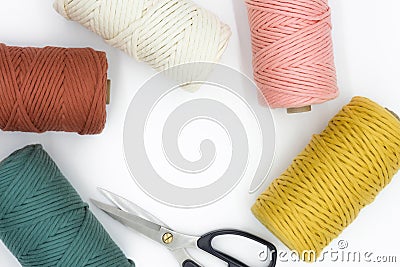 Close-up view of the colorful single strand cotton cords and scissor for macrame DIY handcraft isolated on white background Stock Photo
