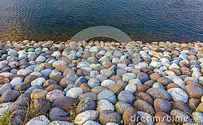 Close-up view of stones of various sizes forming the bank of the Saigawa river which passes through the Stock Photo