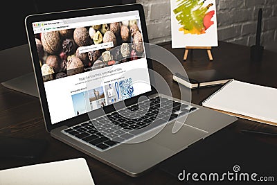 close-up view of designer workplace with notebooks and laptop with depositphotos website Editorial Stock Photo