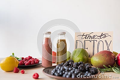 close up view of detox drinks, time to detox card and organic food Stock Photo