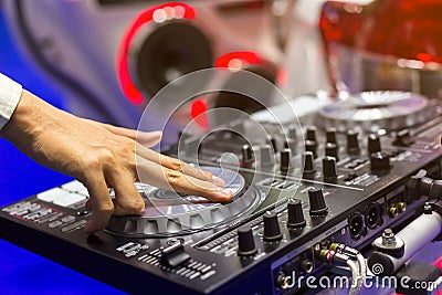 Close up view of DJ`s hand controls on the deck at night. DJ sp Stock Photo