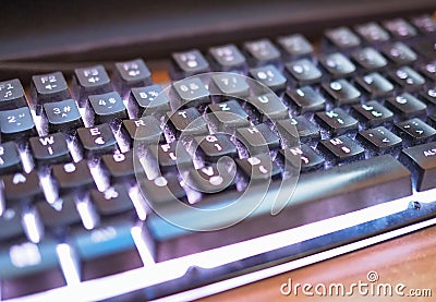 Close-Up View of Dusty Computer Keyboard With Illuminated Keys Stock Photo