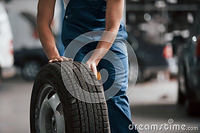 Close up view. Employee in the blue colored uniform works in the automobile salon Stock Photo