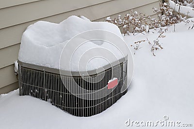 Close up view of an exterior air conditioning unit covered with deep snow Stock Photo