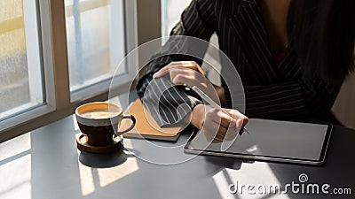 Close up view of female freelancer working on mock up digital tablet in coffee shop Stock Photo