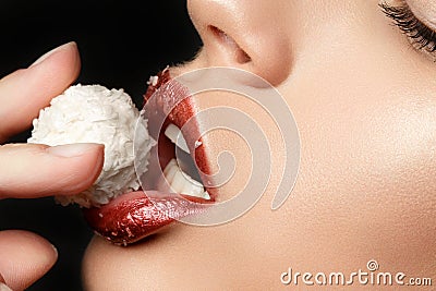 Close up view of female lips eating coconut candy Stock Photo