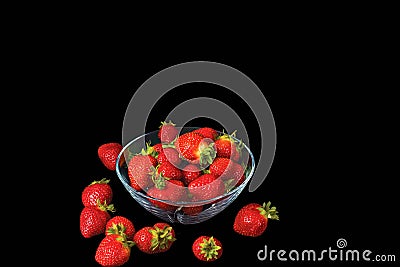 Close up view of fresh red strawberry in glass bowl on blackbackground. Stock Photo