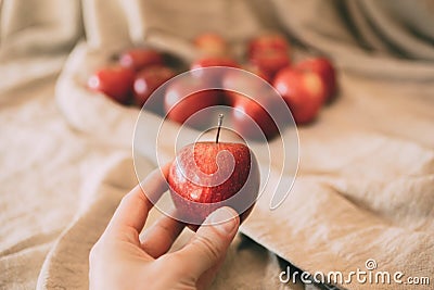 Close up view of girl holding red apple in hand. Organic fruit. Stock Photo