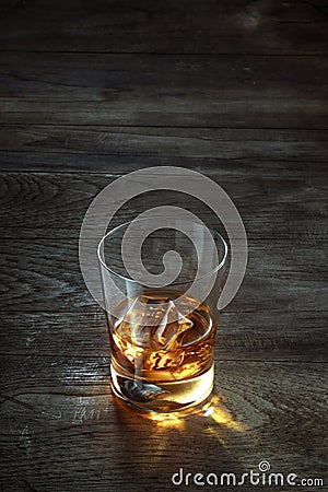 Glass with ice and whiskey on wooden background Stock Photo