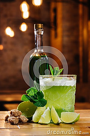 close-up view of green van gogh cocktail in glass with bottle of absinthe on wooden table Stock Photo