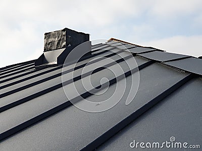 close up view of grey folding roof and chimney on waterproofing layer of house under construction Stock Photo