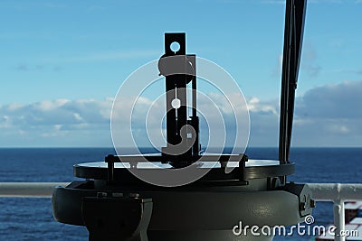 Close up view on the gyro compass repeater with azimut ring. Pacific Ocean and cumulus clouds in the Backgrounds. Stock Photo