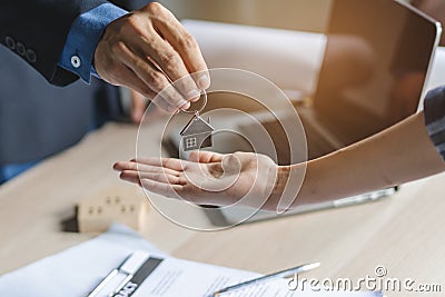 Close up view hand of property realtor / landlord giving key house to buyer / tenant Stock Photo
