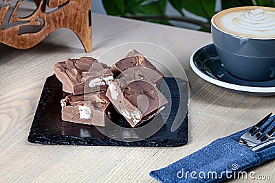 Close up view on homemade chocolate Fudge sugar candy with coffee on wooden table. Stock Photo