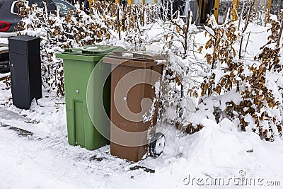 Close up view of house mail post box and waste and recycling containers on snowy bushes background. Stock Photo