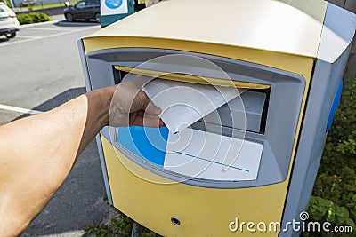 Close up view of male hand posting letter. Correspondence concept Stock Photo