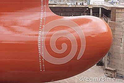 Close up view on the newly red painted bulbous bow of the big container ship. Stock Photo