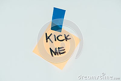 close up view of note with kick me lettering and sticky tape isolated on grey, april fools day concept Stock Photo