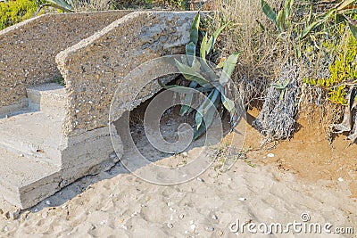 Close up view of okd broken abandoned stone stair part on sandy landscape. Stock Photo