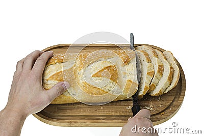 Close up view of partially sliced loaf of white bread on wooden cutting board with bread knife. Stock Photo