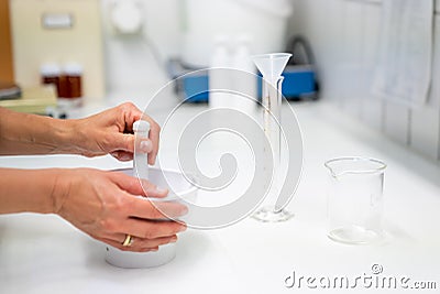 Close up view of a pharmacist in the laboratory mixing a medical ointment in a bowl Stock Photo