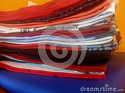 Close up view of a pile of assorted ironed and folded clothes Stock Photo