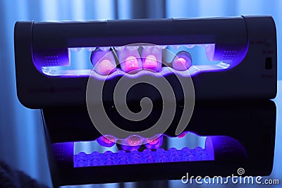 Close-up view of polished nails under the ultra violet lamp Stock Photo