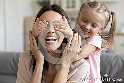 Close up image daughter closes her mother eyes with hands Stock Photo