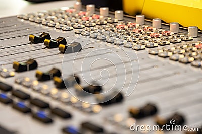 Close-up View of Professional Audio Mixing Console with Focus on Faders and Buttons in Recording Studio Stock Photo