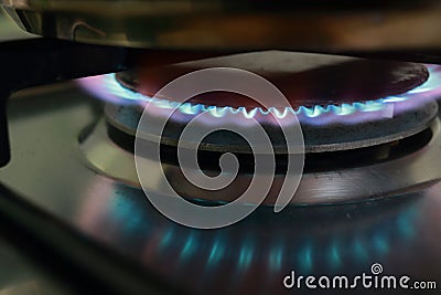 Close-up view on propane butane fuel LPG or petroleum gas kitchen stove hob with blue flame and metal cooking pot Stock Photo