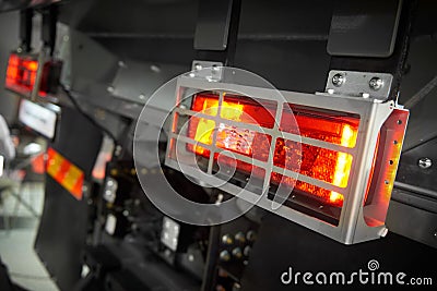 Close up view on rear car tipper truck red and yellow light with silver metal protective shield cover metal housing. Commercial tr Stock Photo