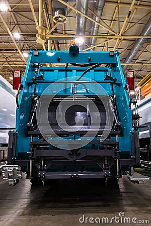 A close-up view of the rear of a garbage truck with the loading mechanism open. The complex machinery and hydraulic systems used Editorial Stock Photo