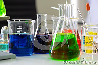Close up view revealed an enchanting sight of beakers and flasks in a myriad of colors their glass surfaces illuminated. Stock Photo