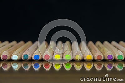 Close-up view of a set of colored pencils lying on a glass mat with reflection Stock Photo