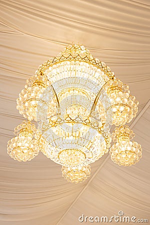 Close up view of single hanging luxury chandelier with white curtains ceiling Stock Photo