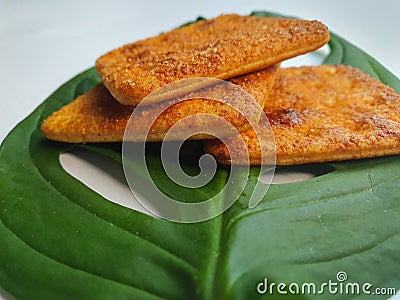 Close up view of a stack of crackers biscuit on an ornamental green monstera leaf. Stock Photo
