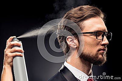 Close-up view of stylist fixing hairstyle for businessman with hairspray Stock Photo