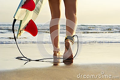 Close up view of surfer walking along beach towards surf Stock Photo