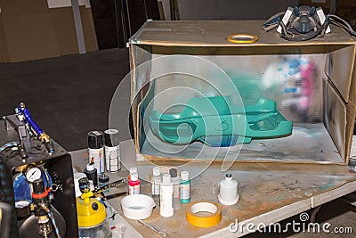 Close up view of table with hand made box for painting of small plastic objects with spray color Stock Photo