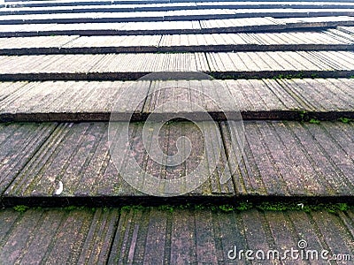 Close-up view of a tiled roof. The tiles are arranged in overlapping rows, creating a textured pattern. Stock Photo