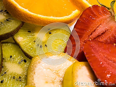 Close-up view on tropical fruits: banana, kiwi, orange, and strawberries Stock Photo