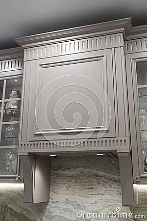 close-up view of under cabinet range hood, exhaust vent hood in kitchen with working lights and marble backsplash Stock Photo