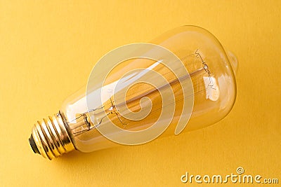 Vintage Style Light Bulb on Yellow Background Stock Photo